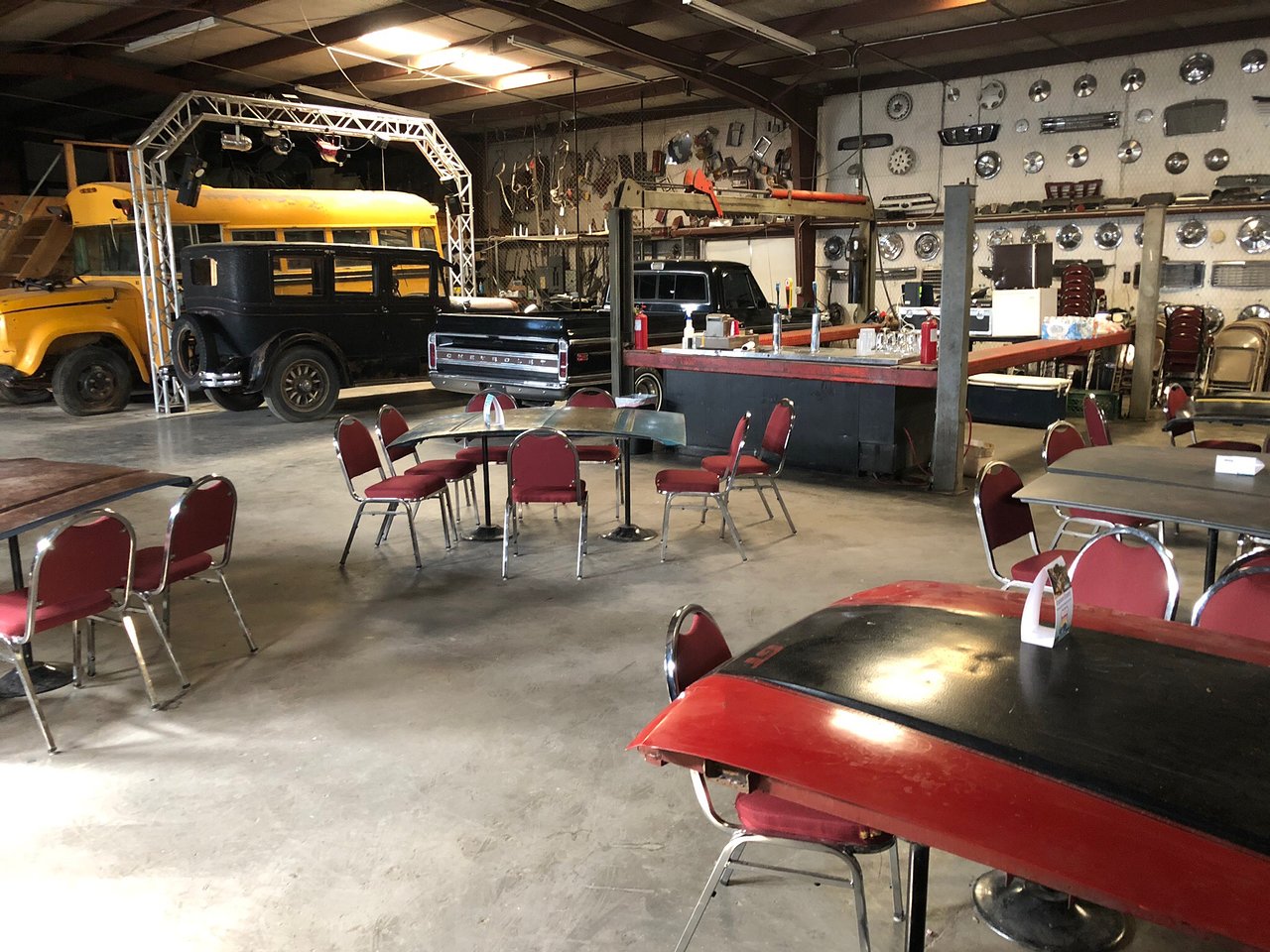 Tables set up in a garage for indoor/outdoor seating at a brewery