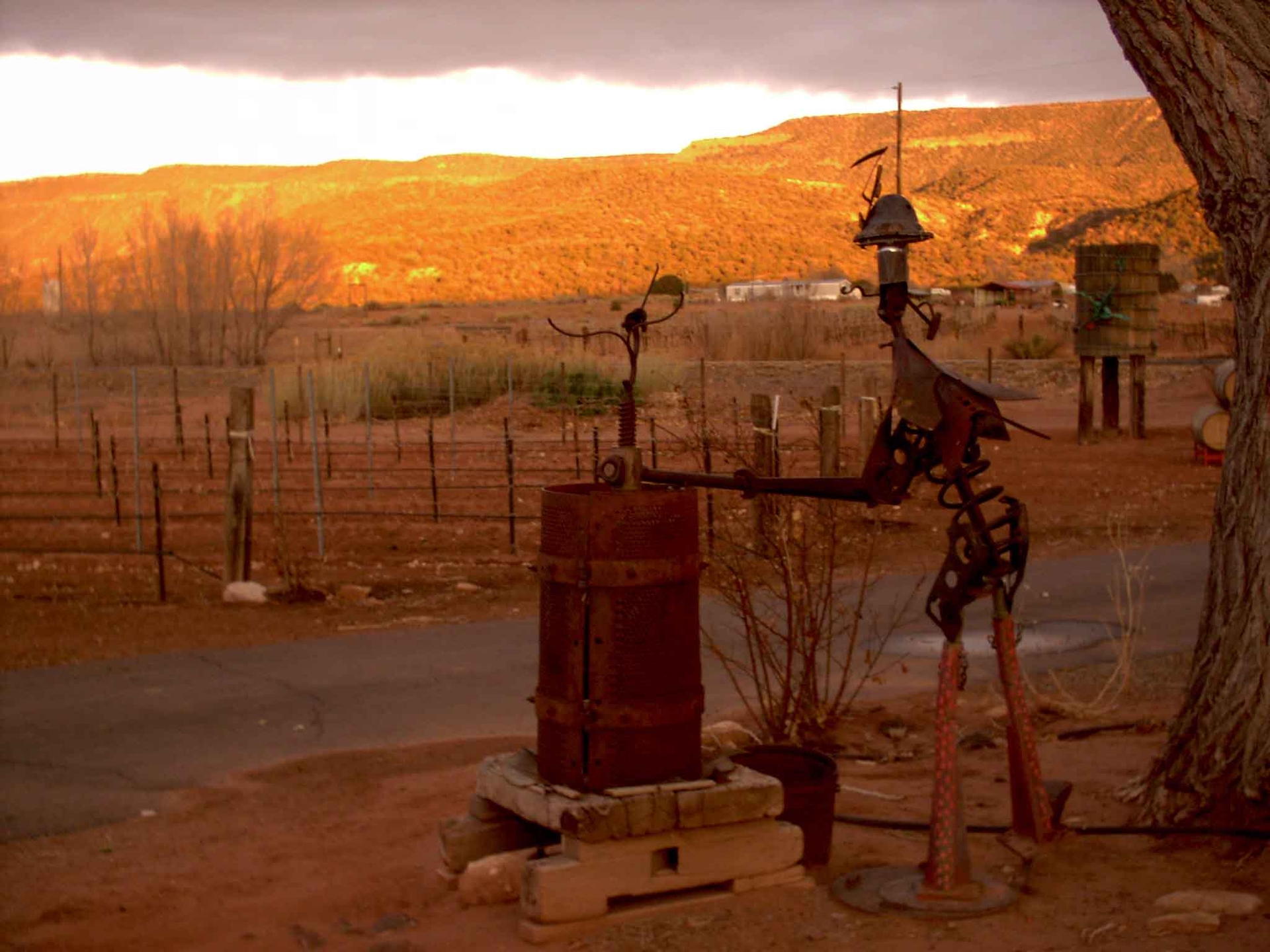 A metal sculpture in the foreground with a sunset in the background